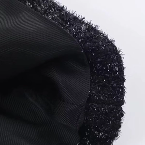 Macro shot of black and silver tweed fabric texture with shimmering sequins and inner lining