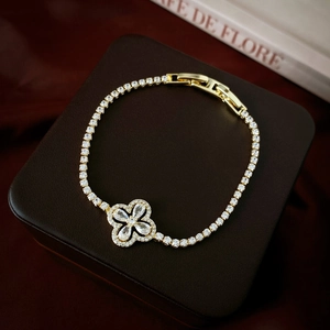Detailed macro of gold four-leaf clover bracelet with sparkling cubic zirconia on leather