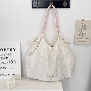 Détail du sac cabas en toile à imprimé cœur avec anses tressées colorées en décor cosy