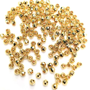 Pile of faceted 14K gold filled spacer beads for DIY jewelry making on white background