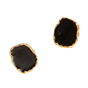 Detailed close-up of organic irregular gold-edged earrings with glossy black enamel inlay