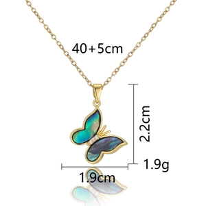 Detail view of a gold titanium butterfly necklace with blue shell inlay and rhinestones