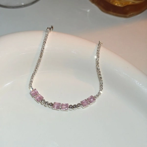 Detailed macro view of luxury silver bracelet featuring pink rectangular zircon gemstones
