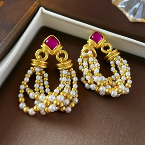 Detail of vintage palace style earrings with red stones and pearl tassel woven fringe