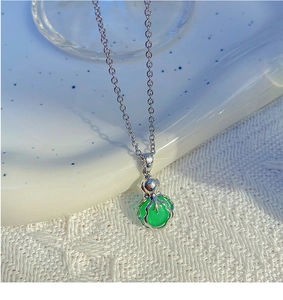 Détail du collier chaîne argenté avec pendentif en pierre vert émeraude en forme de gourde