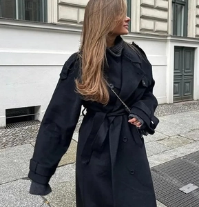 Détail d'un long manteau noir en laine pour femme avec double boutonnage et ceinture