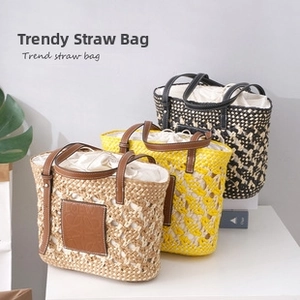 Three handmade straw tote bags in various colors with leather straps and drawstring liners