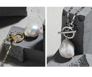 Macro detail of Baroque pearl necklace with gold and silver OT buckle on stone