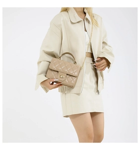 Vue détaillée du sac à main matelassé beige avec fermoir doré et bandoulière sur mannequin