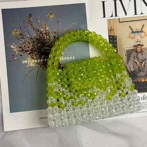 Detail shot of green and clear acrylic beaded handbag showing the weave texture and handle