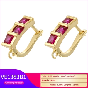 Macro view of gold plated brass geometric earrings featuring three rectangular red stones