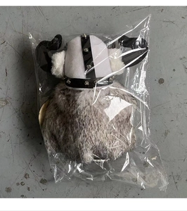 Detail view of Viking gnome plush with horn helmet and faux fur in clear plastic packaging