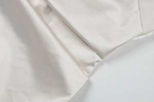 Detailed view of high-quality champagne satin fabric with soft folds and silk-like shine
