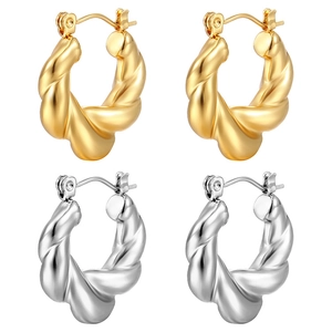 Elegant twisted hoop earrings set in polished gold and silver finishes on white background