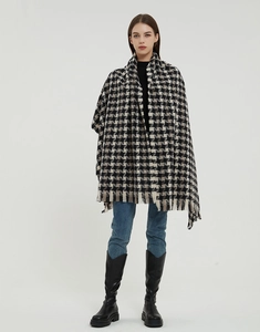 Detail of classic black and white houndstooth shawl with elegant fringe edges for winter