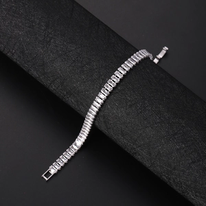 Close-up of rectangular clear zircon tennis bracelet with silver-tone chain on black
