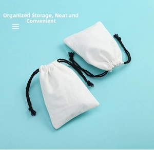 Detail of white cotton drawstring pouches with thick black cords for jewelry storage