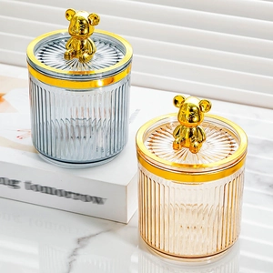 Detail of food-grade storage jars with golden bear handles and vertical textures