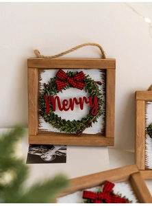 Detail of wooden Merry Christmas door sign with green wreath and buffalo plaid bow