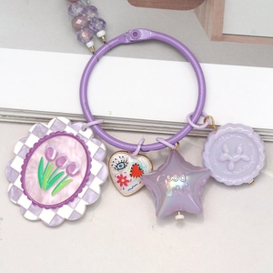 Colorful dopamine-style purple keychain with floral and star pendants on white background