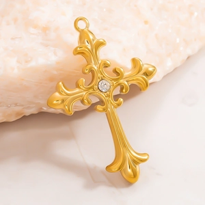 Ciondolo croce barocca in oro 18K con motivi a volute e un chiaro zircone centrale