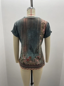 Detail view of ethnic floral print on the back of a blue summer short sleeve t-shirt