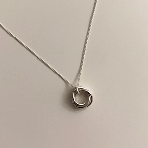 Detail view of interlocking triple ring pendant on a minimalist silver chain necklace