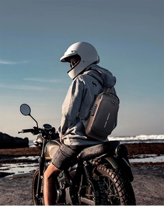 Business chest bag with TSA lock shown on a rider with a vintage motorcycle by the beach