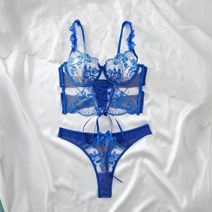 Detail of royal blue lace lingerie set with floral embroidery and lace-up front details