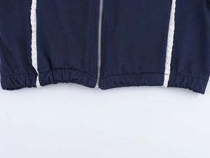 Détail du sweat bleu marine avec fermeture éclair argentée et bordure en dentelle blanche