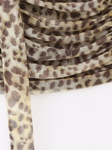 Détail d'une jupe en tulle léopard avec texture froncée et cordon de serrage assorti