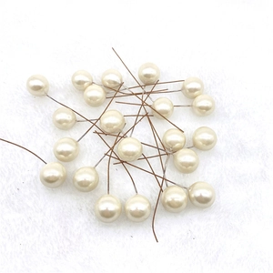 Detailed macro shot of cream faux pearl stamens with flexible brown wire for DIY crafts