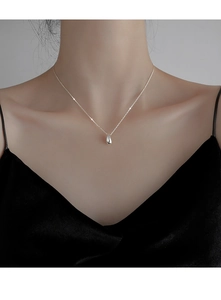 Detail view of a polished S925 sterling silver water drop pendant necklace on a model