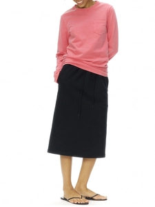 Front view of women's pink long sleeve pocket t-shirt with black drawstring skirt