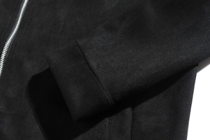 Detail of black matte suede jacket showing silver metal zipper and premium texture