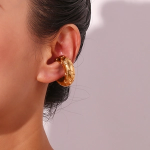Close-up of 18K gold-plated ear cuff featuring embossed heart patterns on the ear