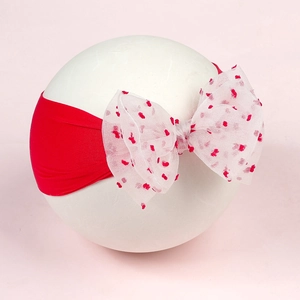 Red knit baby headband with a large white polka dot organza bow for Christmas