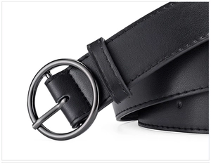 Detail of black textured PU leather belt with round metal buckle for women's jeans