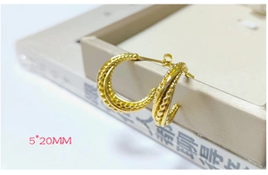 Close-up of 20mm golden beaded texture hoop earrings with 5mm width on a jewelry box