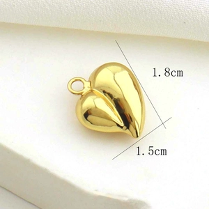 Detail view of 1.8cm x 1.5cm gold heart pendant showing dimensions on fabric