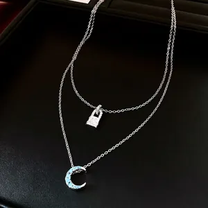 Collier double épaisseur avec cadenas en zircon et pendentif lune bleue sur fond noir