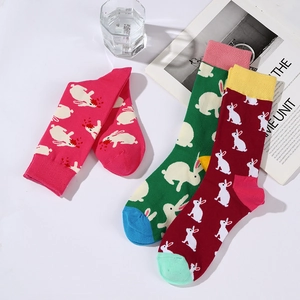 Three colorful mid-calf socks with white rabbit patterns in pink, green, and dark red