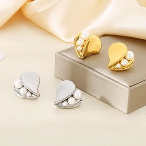 Detailed view of heart-shaped pearl earrings on champagne silk and jewelry box