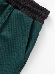 Détail du tissu gaufré et de la taille élastique sur un short décontracté vert forêt