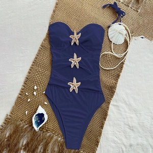 Navy blue cutout one-piece swimsuit with golden starfish accents and halter straps