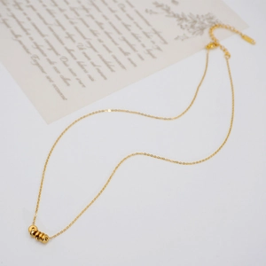 Minimalist gold titanium necklace with five delicate small rings on a dainty chain