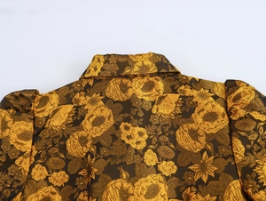 Detail view of gold floral brocade fabric on a vintage court style long sleeve dress
