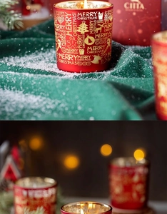 Detail der roten Weihnachtskerze mit goldener Aufschrift auf künstlichem Schnee