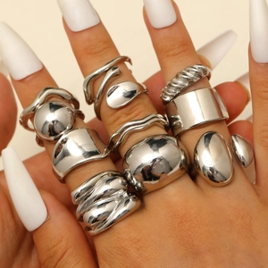 Detailansicht silberner Stapelring-Sets mit Lava-Wellen und geometrischen Tropfenformen