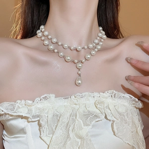 Double-layered water drop pearl necklace and earrings set worn on a model with lace top